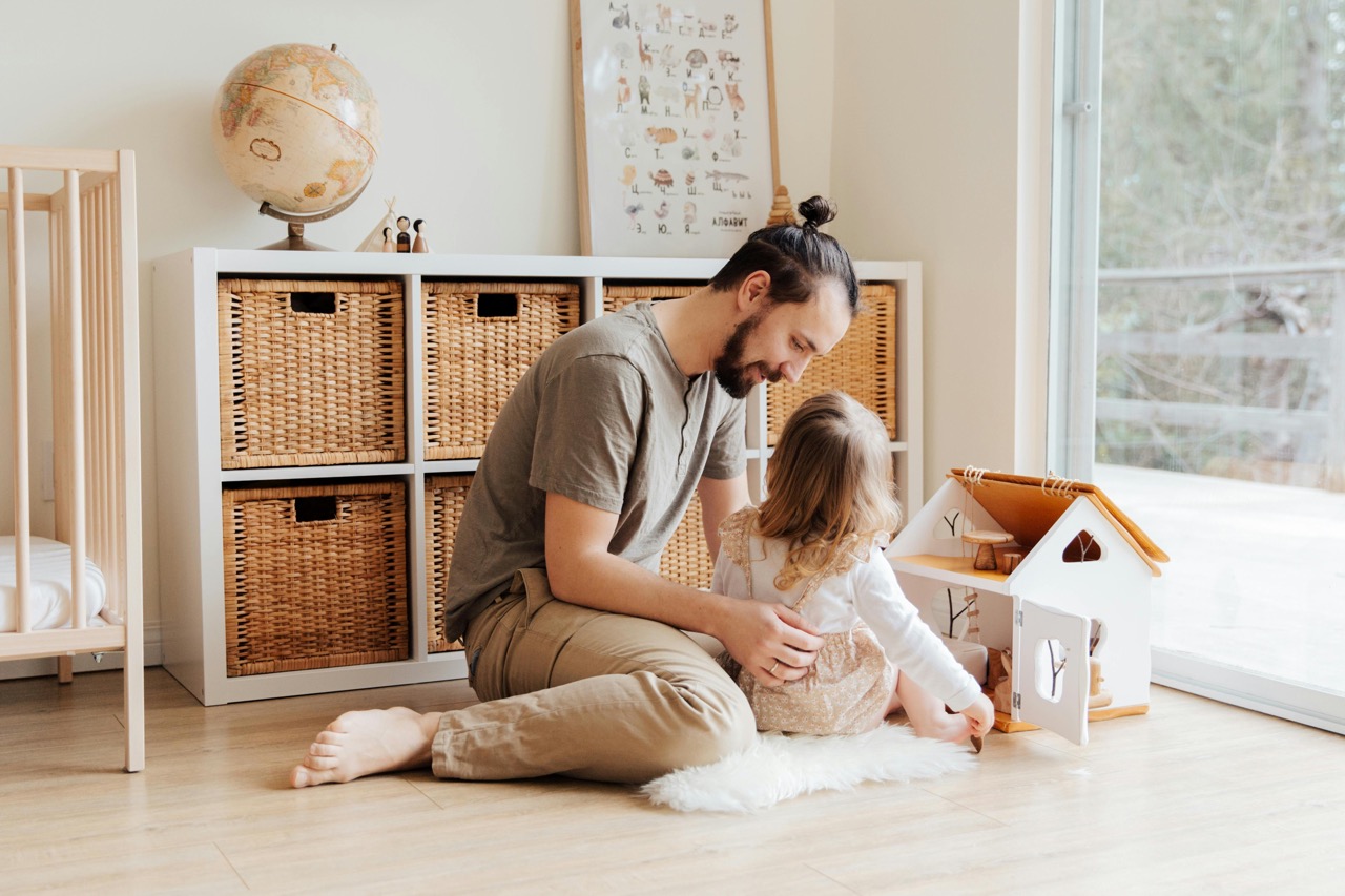 Father sitting with daughter on bedroom floor